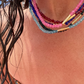 Close-up of a person wearing colorful beaded necklaces with a blurred background