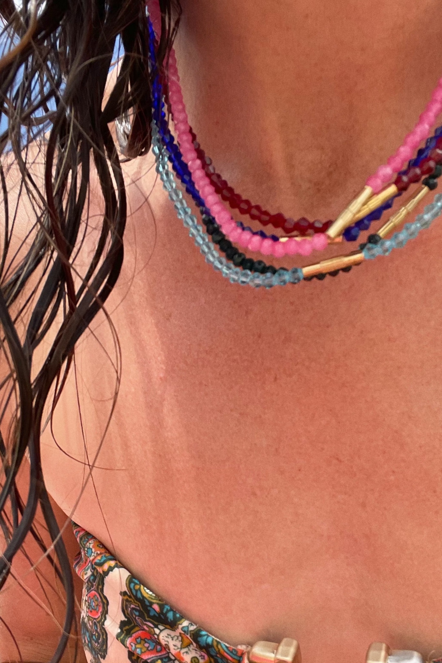 Close-up of a person wearing colorful beaded necklaces with a blurred background