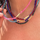 Close-up of a person wearing colorful beaded necklaces with a blurred background