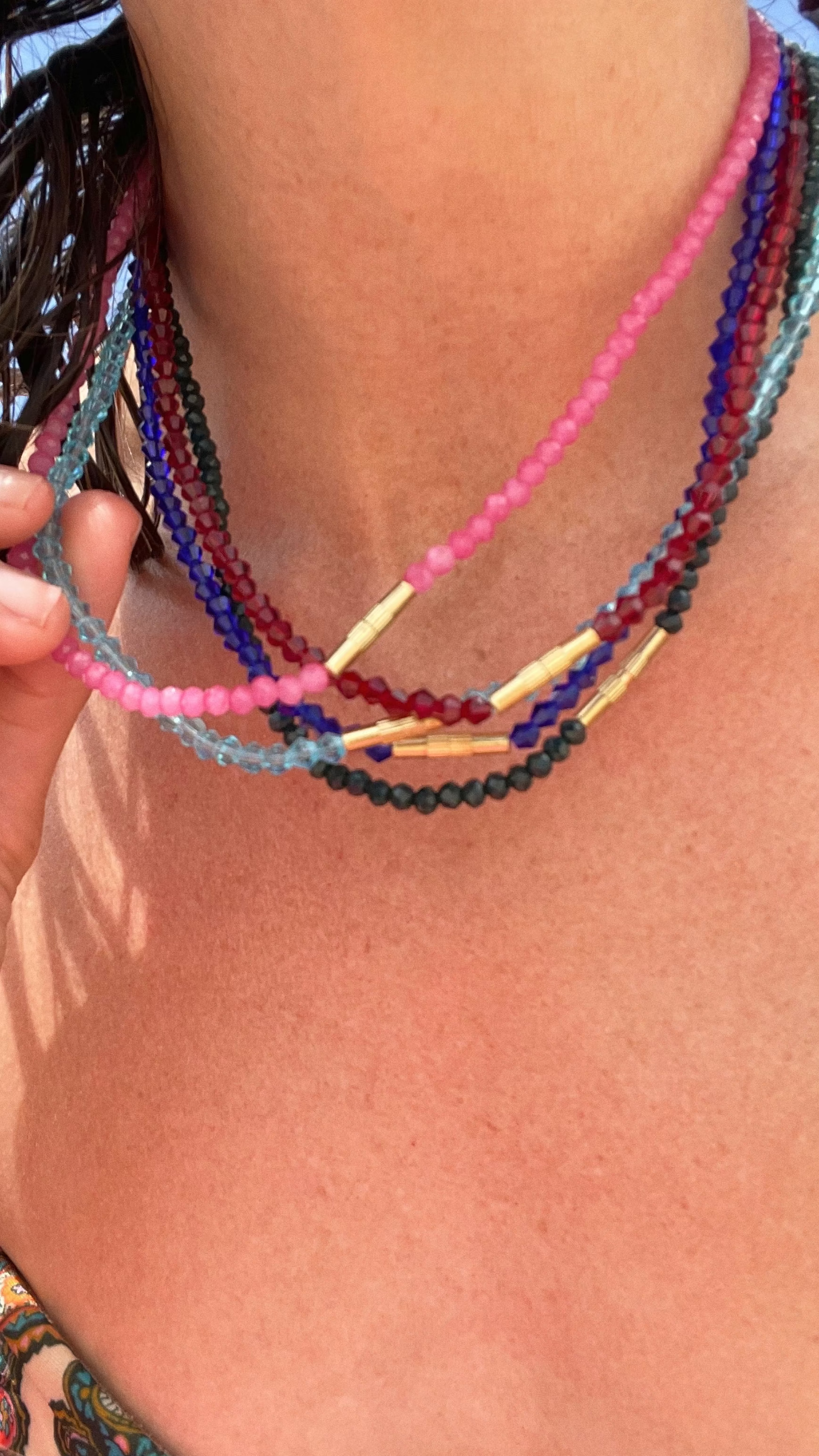Close-up of a person wearing colorful beaded necklaces with a blurred background